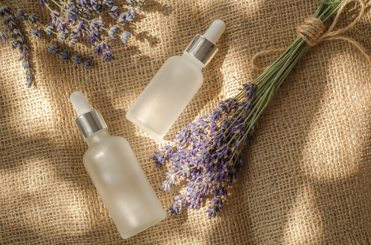 White frosted lavender oil bottle and fresh lavender flowers