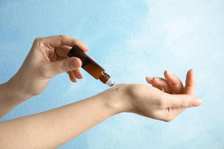 applying essential oil on her wrist 